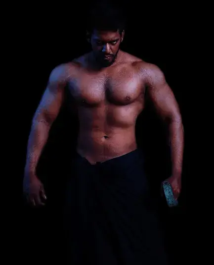 Coach and founder Chinthaka, shirtless and muscular, photographed against a black background